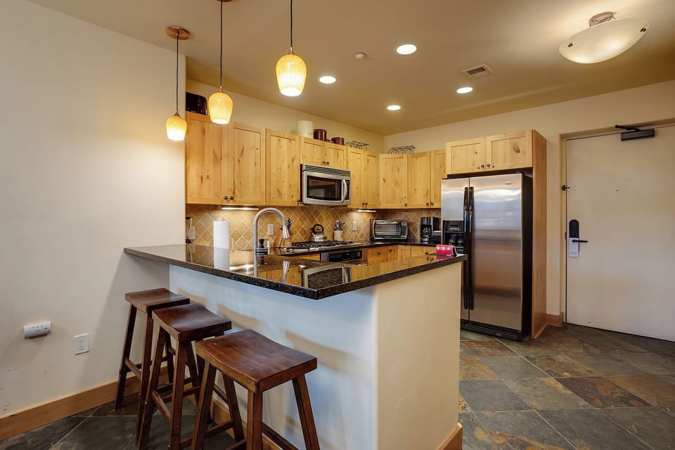 Your fully equipped kitchen features granite counters, stainless appliances, and a breakfast bar where you can enjoy morning coffee.