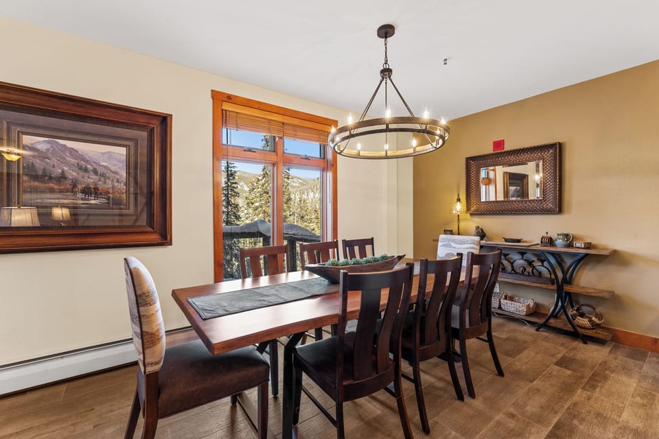 Gather around this elegant dining table where mountain views through large windows create the perfect backdrop for memorable meals together.