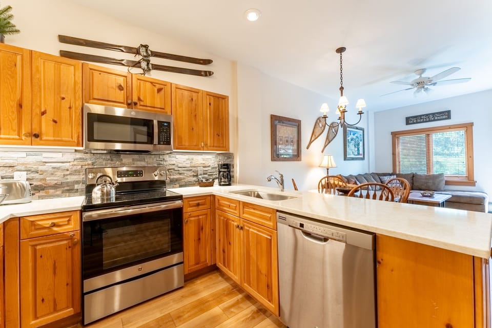 Your fully equipped kitchen features warm wood cabinets, stainless appliances, and granite counters perfect for preparing mountain meals together.