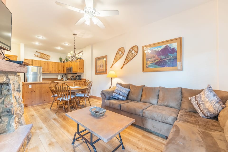 Relax in your open-plan living space with cozy sectional seating, rustic decor, and a fully equipped kitchen ready for home-cooked meals.