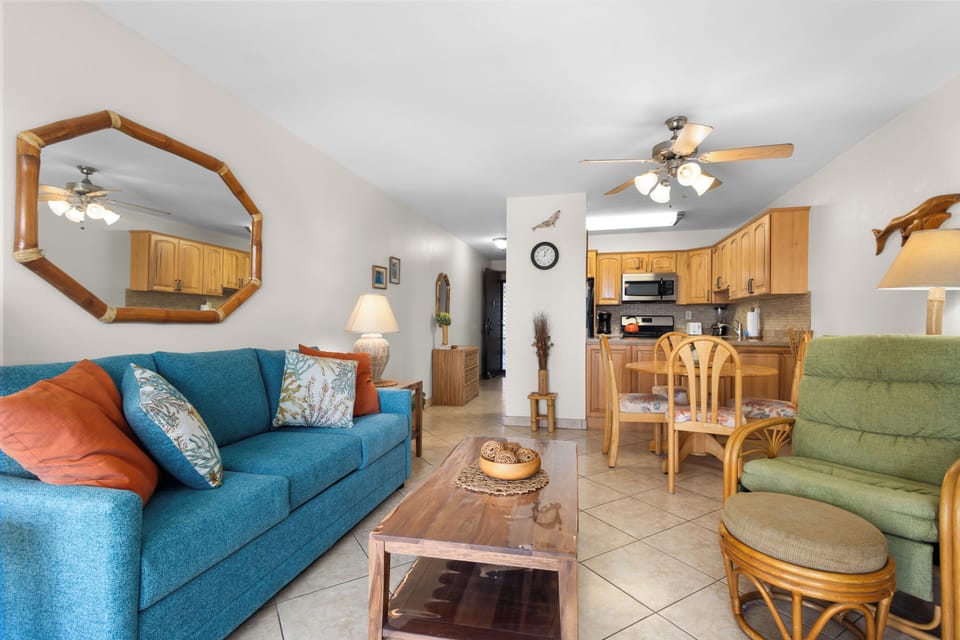 Relax in your spacious, open-plan living area with cozy seating, tropical décor, and a fully-equipped kitchen—your home base for coastal getaways.