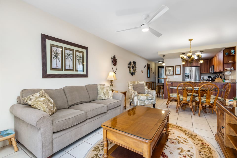 Relax in this inviting open-concept space where soft island breezes from the ceiling fan cool you while you unwind on comfortable seating. The living area flows seamlessly into your fully-equipped kitchen and dining area.