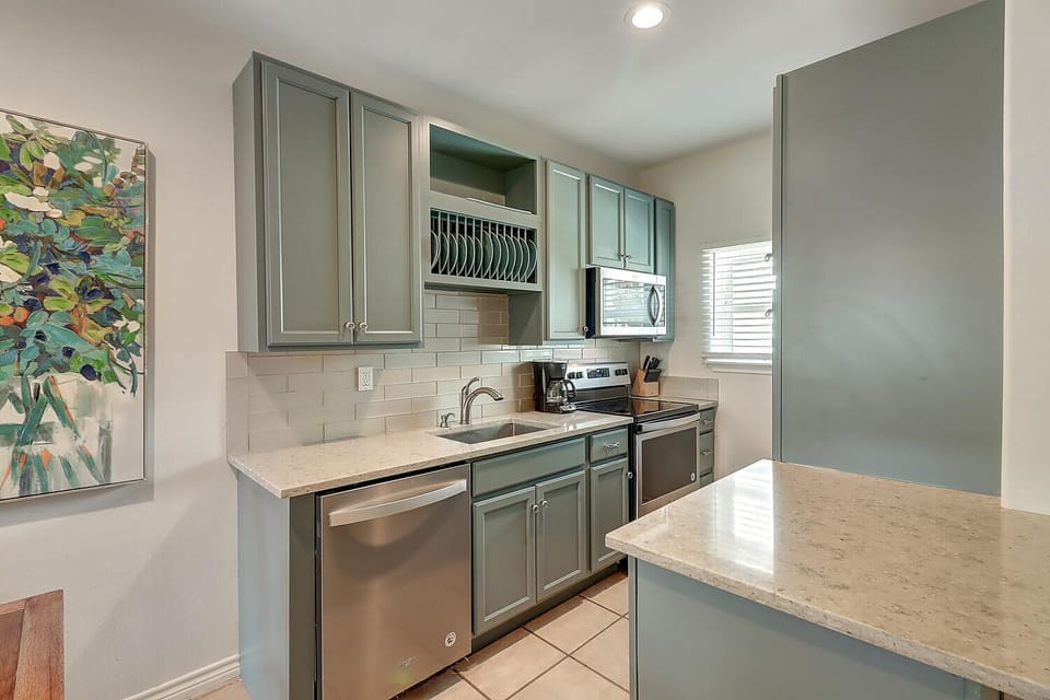 Your fully equipped kitchen features elegant sage cabinets, granite counters, and stainless appliances for effortless meal preparation.