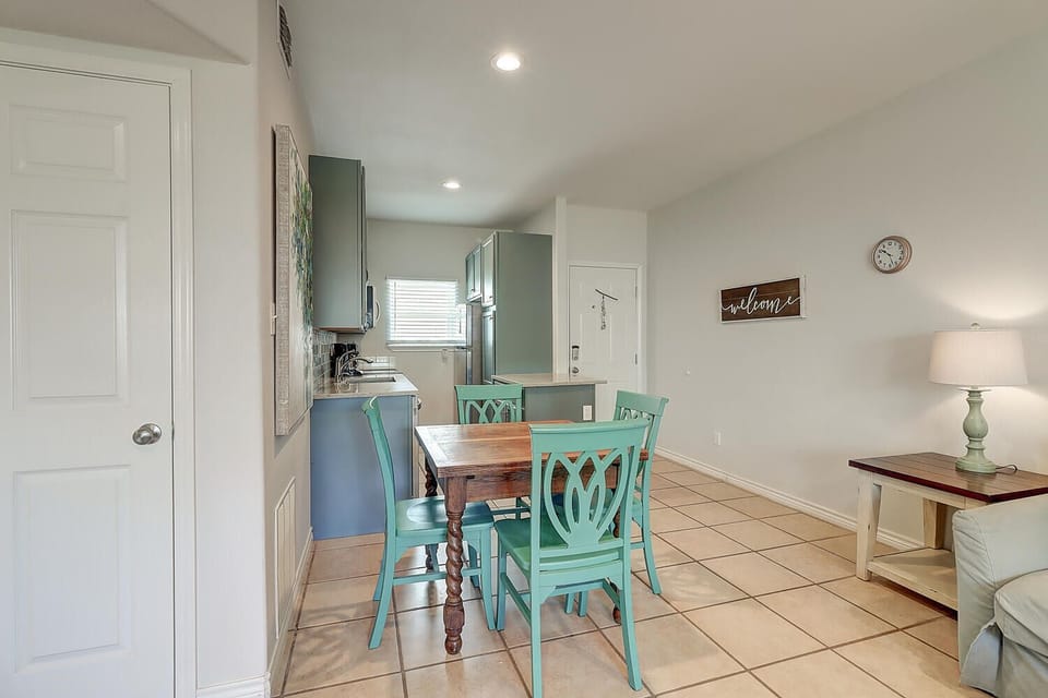 Your cozy open-plan kitchen and dining area welcomes you with charming turquoise chairs and warm touches for memorable meals together.