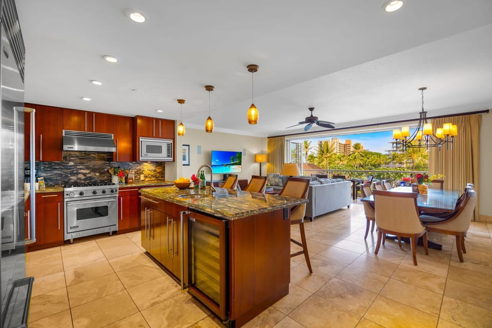 Fully equipped kitchen with stainless appliances and breakfast bar opens to the living space.