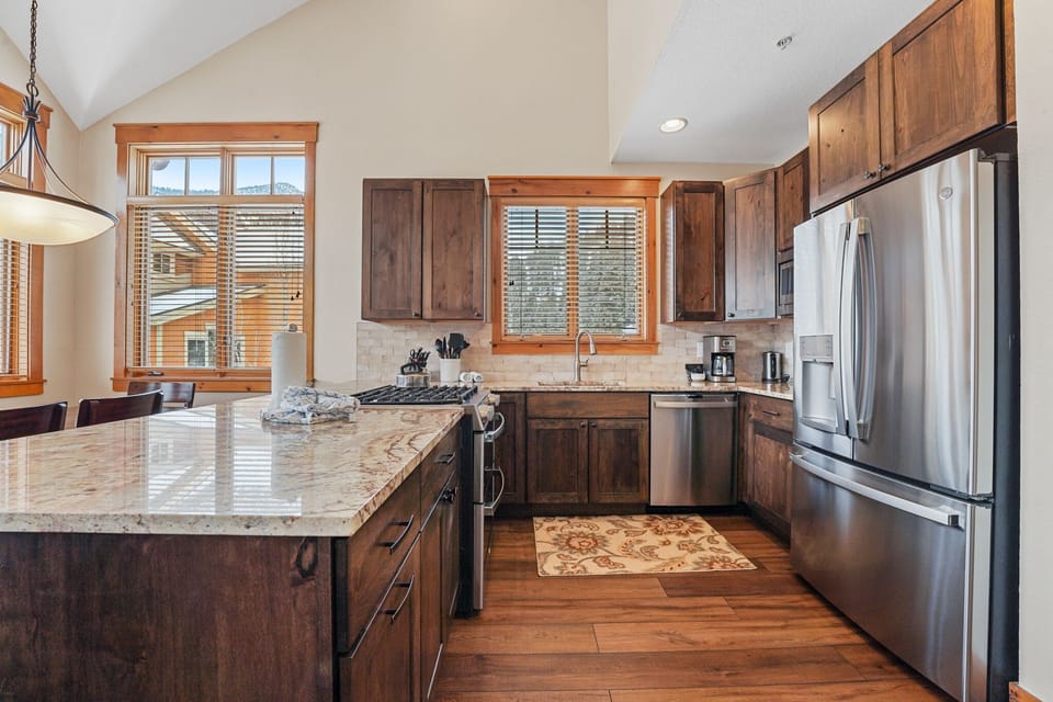 Your gourmet kitchen awaits with granite counters, stainless appliances, and warm wood finishes - perfect for creating memorable meals together.