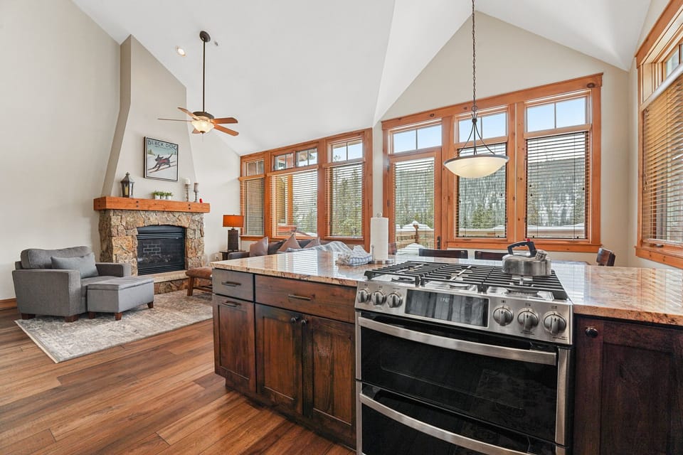 Cook gourmet meals while enjoying mountain views from your open kitchen, then unwind by the cozy fireplace in this stunning great room.