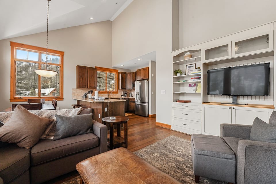 Unwind in your open-concept living space where rich hardwood floors and soaring ceilings create an elegant mountain retreat atmosphere.
