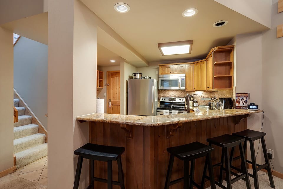 Your fully equipped kitchen features granite counters, stainless steel appliances, and a breakfast bar where you can enjoy morning coffee together.