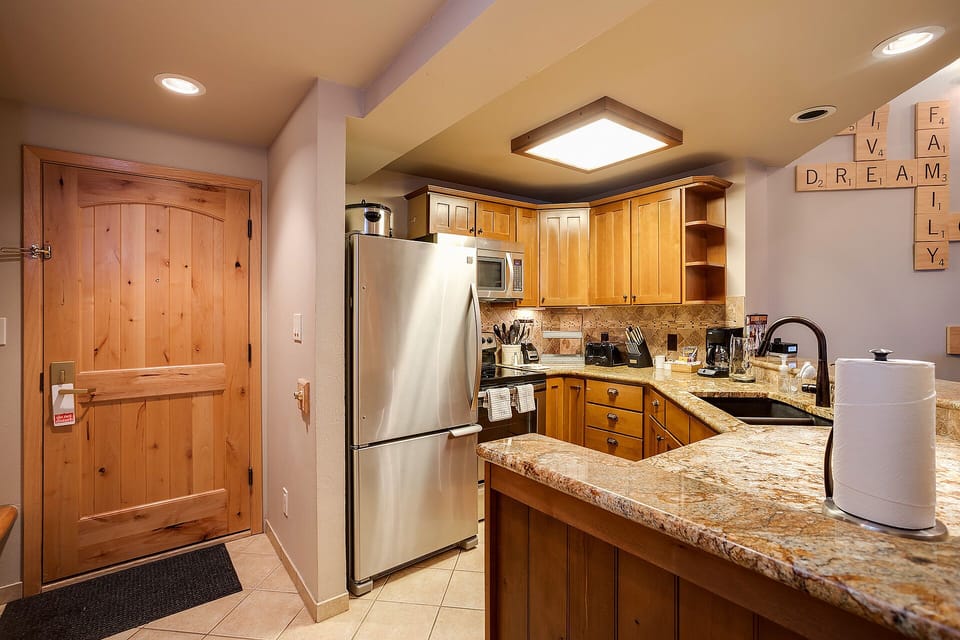 Your fully equipped kitchen awaits with granite counters, stainless appliances, and warm wood cabinets—perfect for creating memorable meals together.