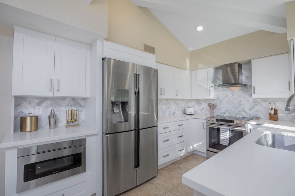 Fully updated kitchen with quality appliances, marble backsplash, and quartz.
