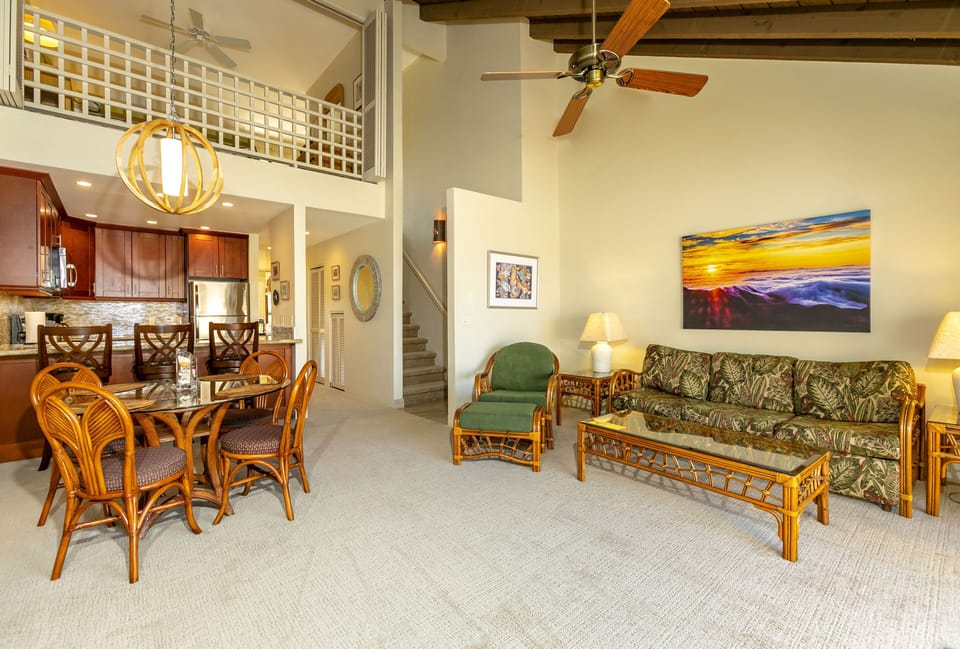Relax in your spacious open-concept living space with soaring ceilings, tropical-inspired furnishings, and vibrant artwork. Natural light flows through the loft, complementing the polished kitchen and cozy dining area—your perfect home away from home.