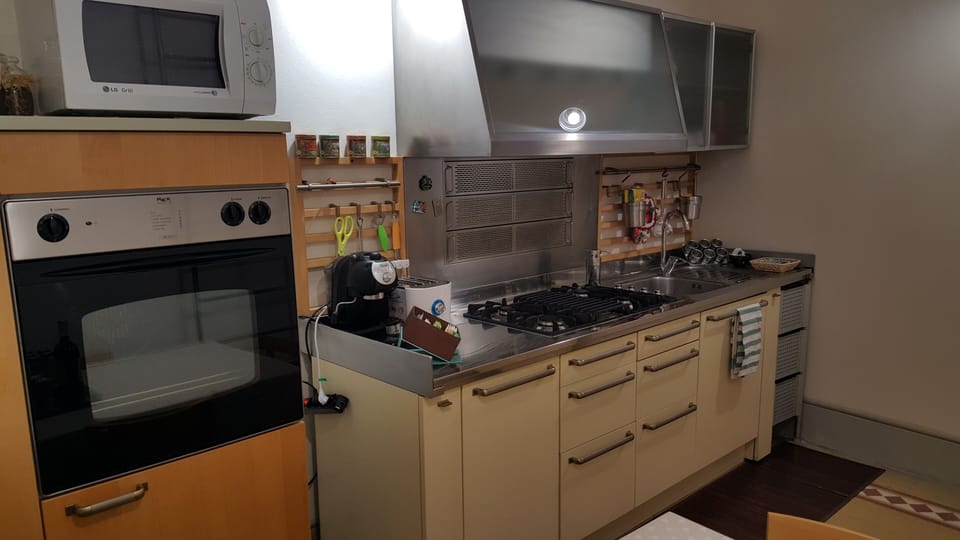 modern kitchen equipped with oven, microwave oven, coffee maker, electric kettle