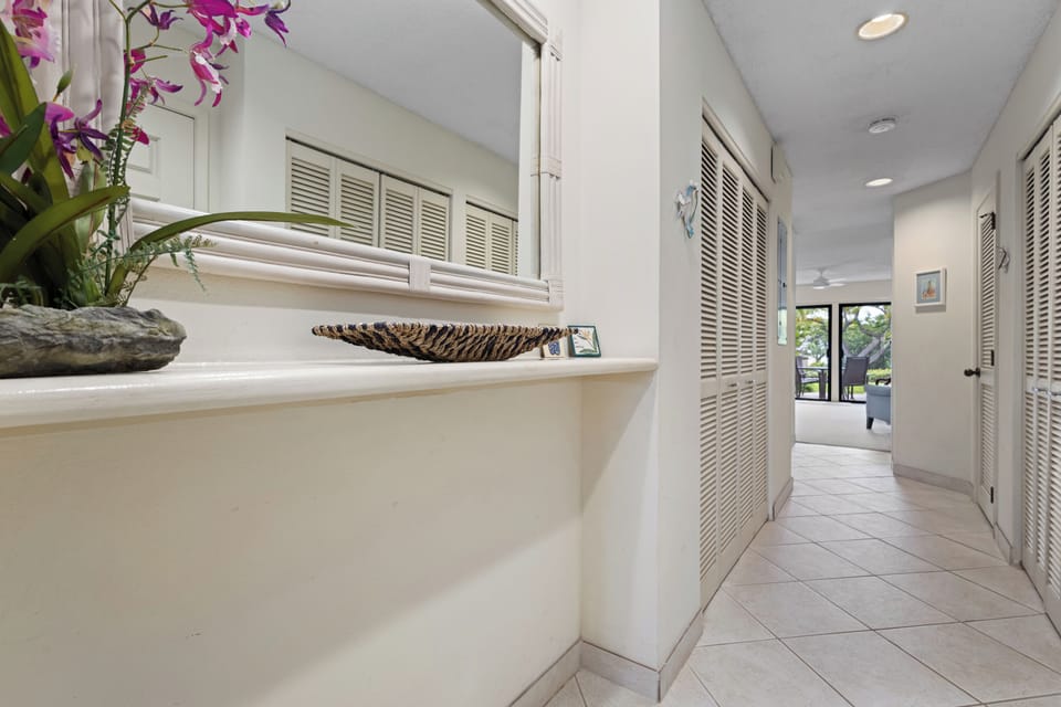 Step into a bright, airy hallway that flows seamlessly through your home. The elegant louvered closets and cheerful floral accents create a welcoming retreat where relaxation begins the moment you arrive.