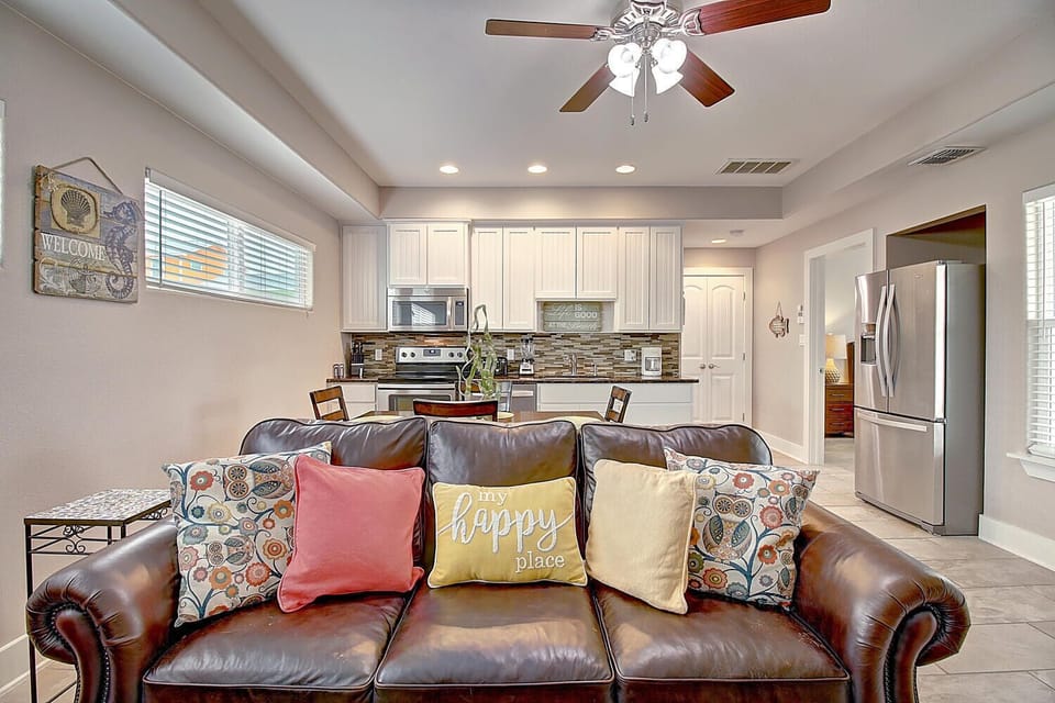 Sink into plush leather seating in this open-concept living area, where kitchen conversations flow effortlessly into cozy moments by the happy place.