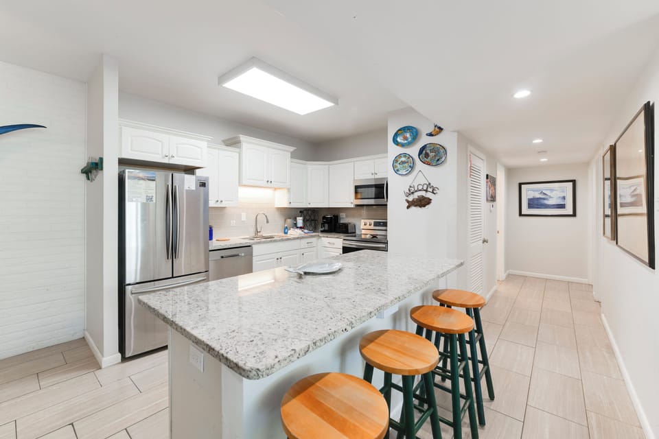 Your modern kitchen features granite countertops, stainless appliances, and coastal charm with breakfast bar seating for four.