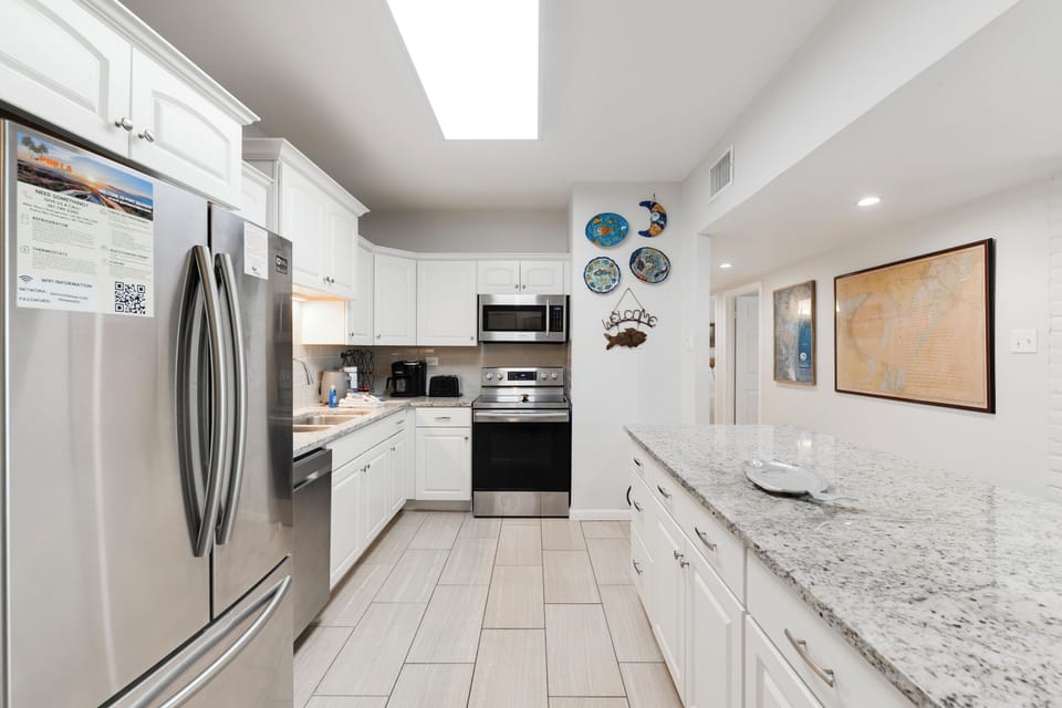 Your fully-equipped kitchen features granite countertops, stainless steel appliances, and bright skylights, perfect for preparing memorable meals during your stay.