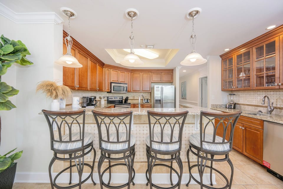 Kitchen with granite countertops, stainless appliances, and stylish bar seating for a perfect gathering spot