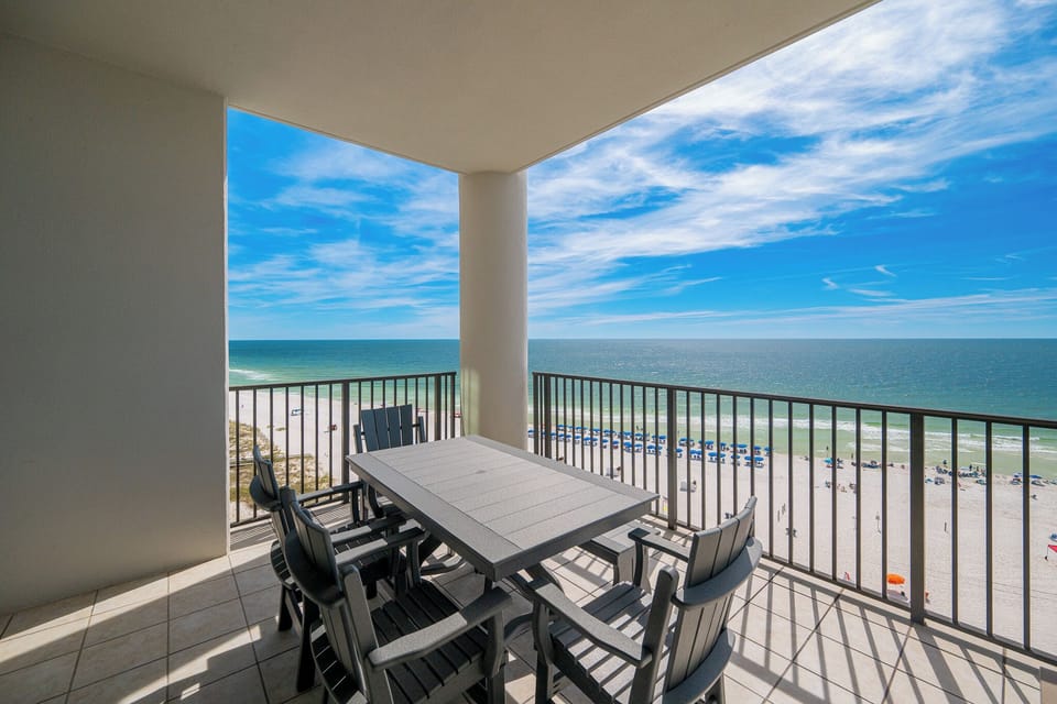 Experience spectacular views from the spacious balcony, featuring a dining table and comfortable seating for relaxation