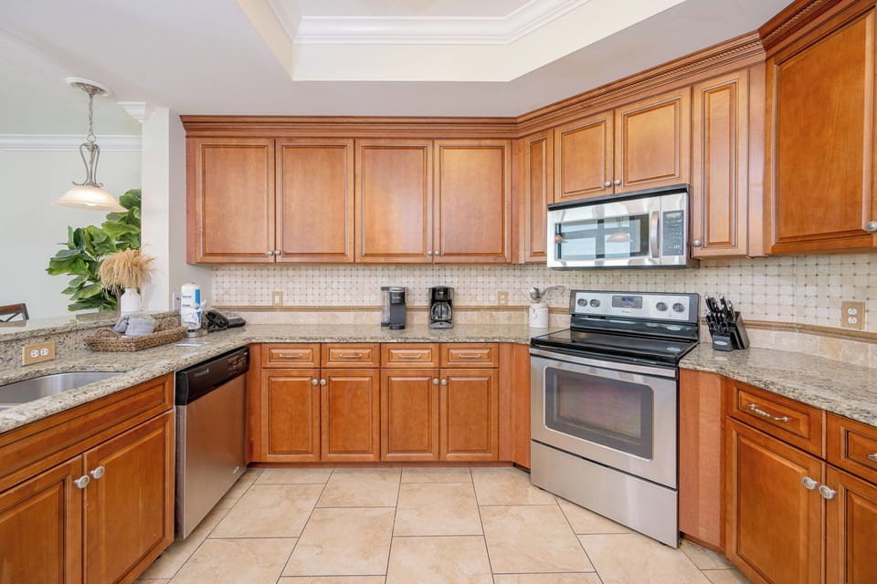 Kitchen featuring stainless appliances, granite countertops, Keurig, coffee maker and warm wood cabinetry