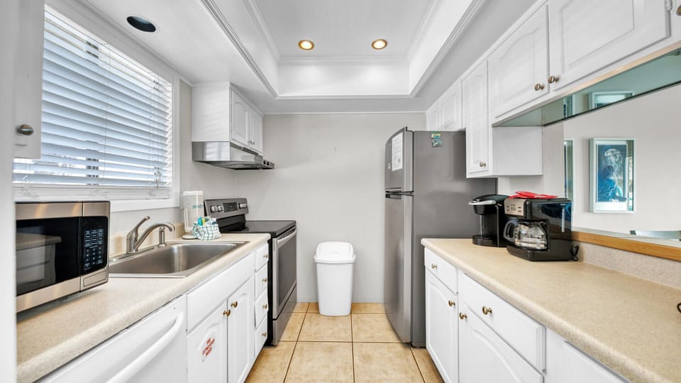 Entry way of the Kitchen area with an open window looking out the living room and back deck.