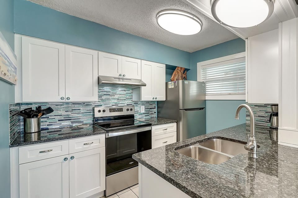 Your fully equipped kitchen features granite counters, stainless appliances, and coastal-inspired tile that makes cooking feel like a breeze.