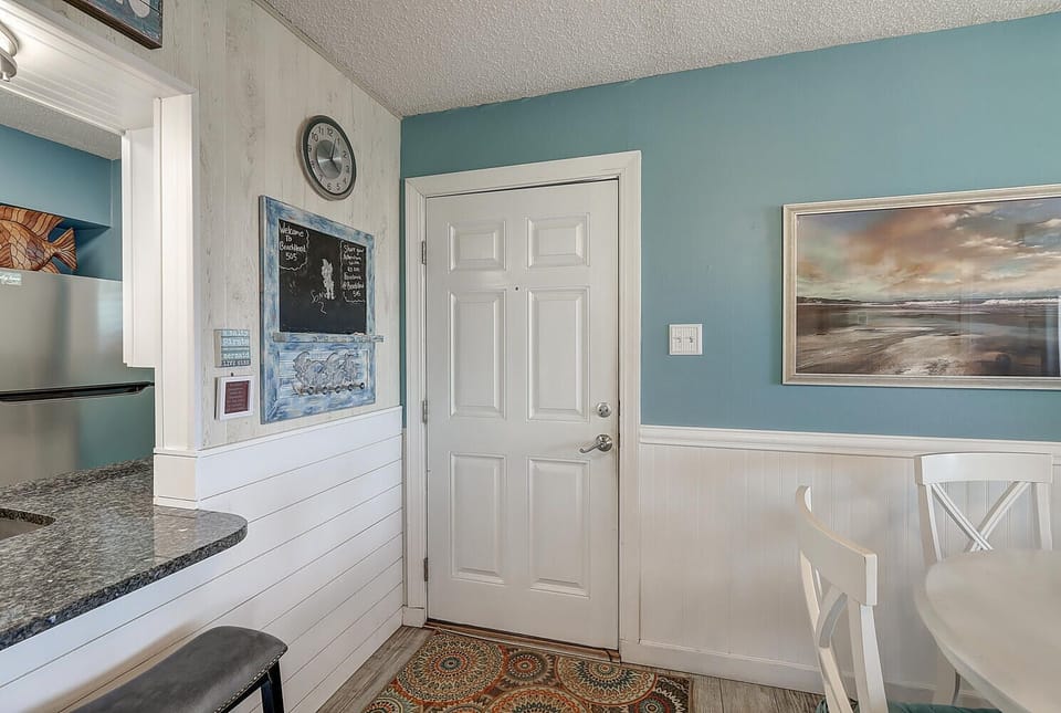 Your coastal kitchen welcomes you with soothing blue walls, granite counters, and charming wainscoting that creates a perfect beach house feel.