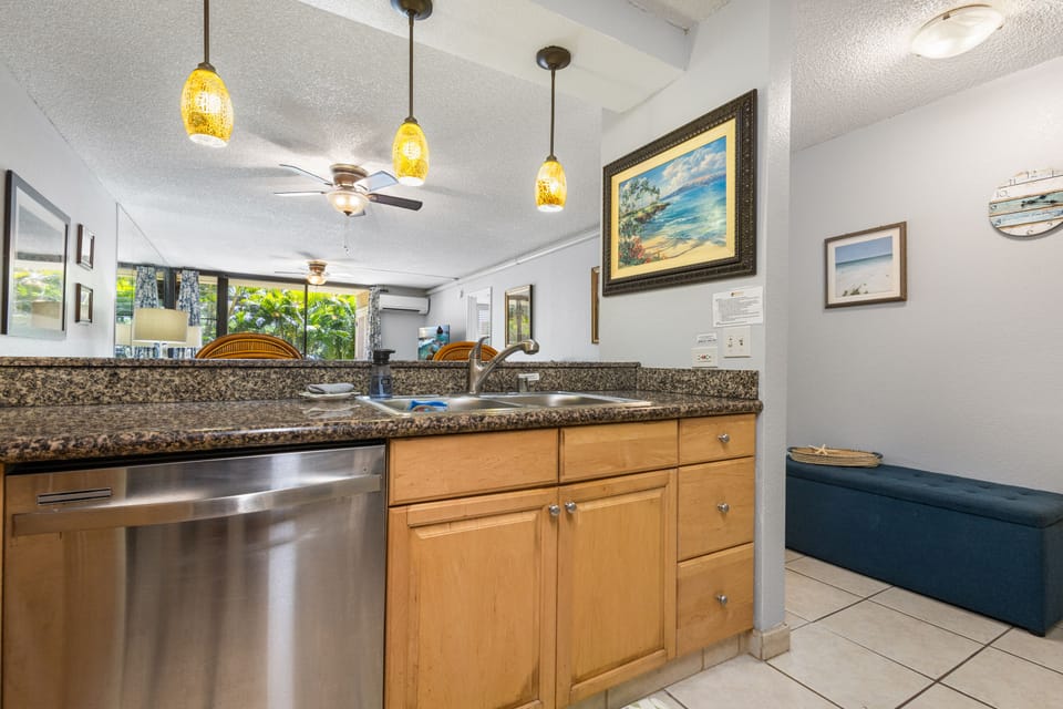 Your kitchen gleams with granite countertops and stainless steel appliances, while warm pendant lights and coastal artwork create an inviting space where you'll enjoy meal prep together.