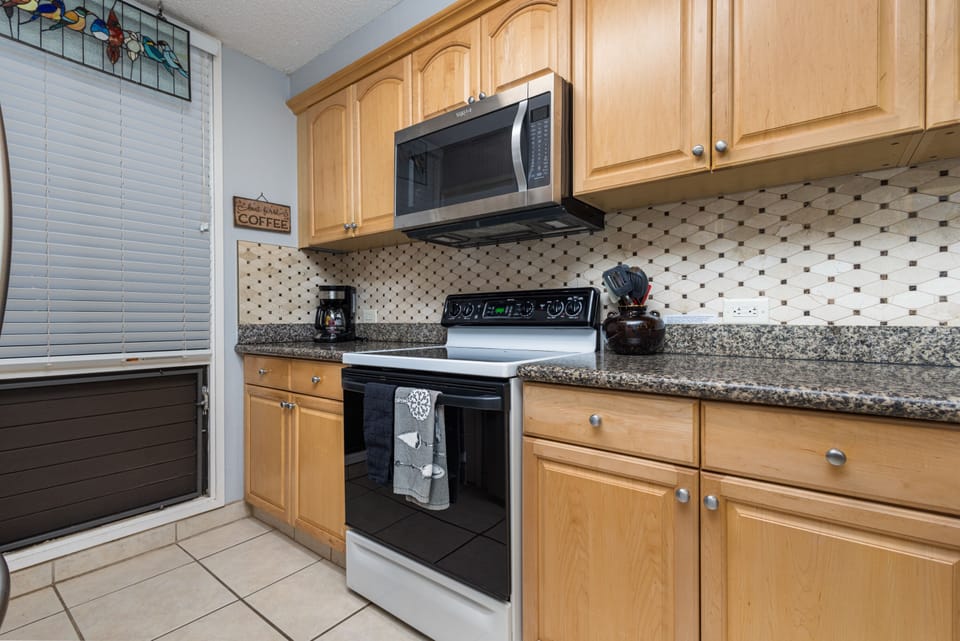 Cook your favorite meals in this well-equipped kitchen featuring granite countertops, modern appliances, and ample cabinet space for all your vacation essentials.