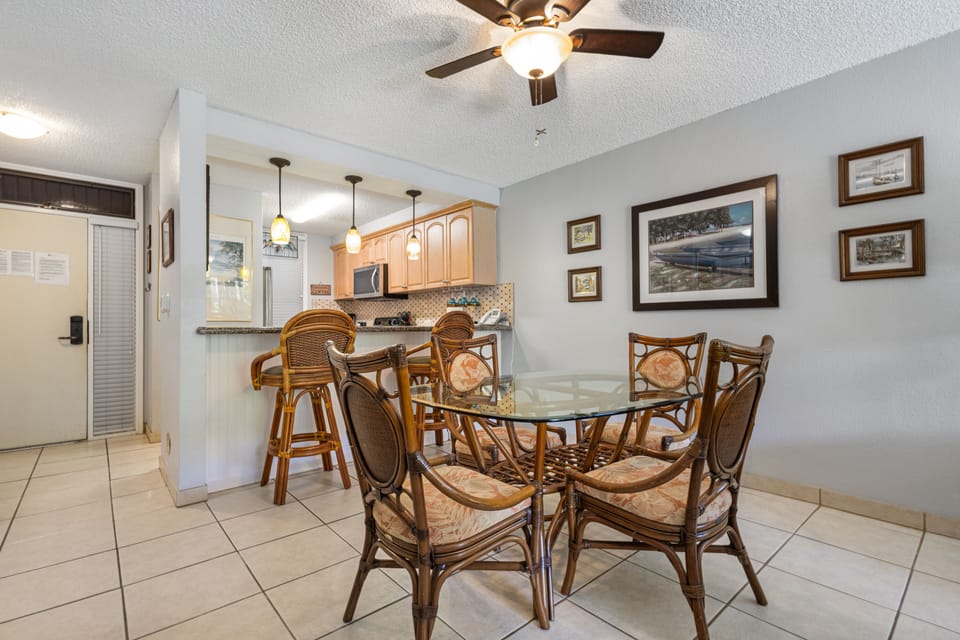 Gather around this charming dining table with comfortable woven chairs, perfect for enjoying meals together. The open layout flows into your fully-equipped kitchen, creating a welcoming space for your stay.