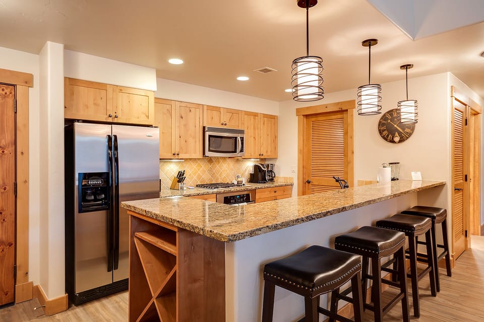 Your fully equipped kitchen features granite counters, stainless appliances, and a breakfast bar where you can enjoy morning coffee together.
