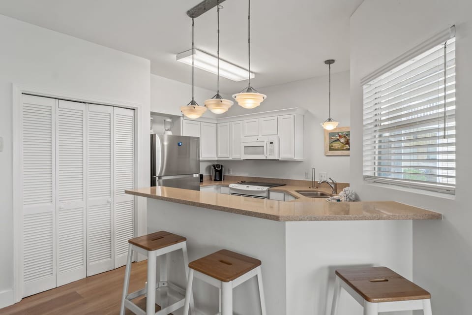 Your modern kitchen offers everything you need with sleek pendant lighting, breakfast bar seating, and stainless steel appliances for memorable meal preparation.