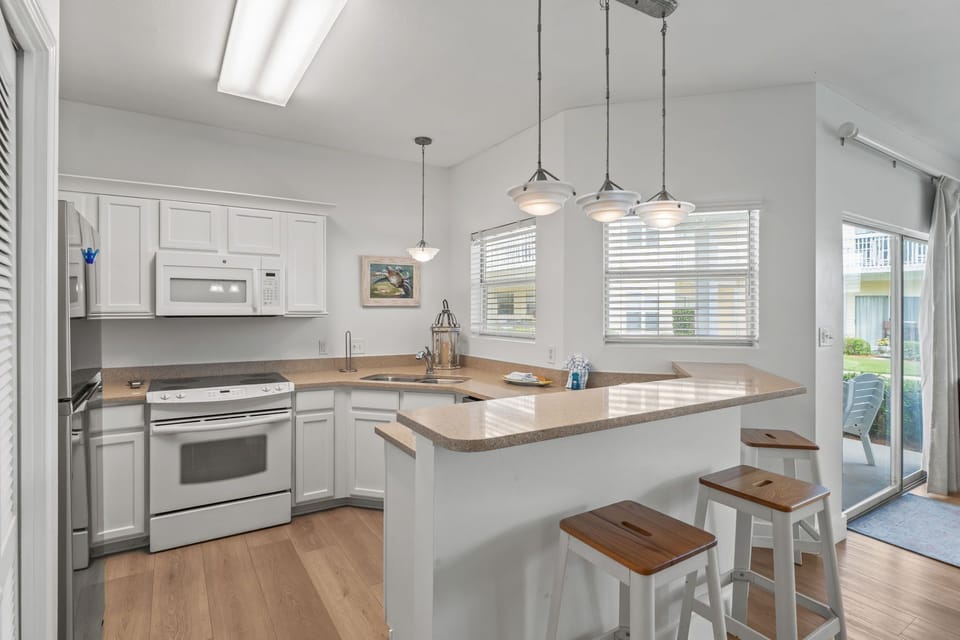 Gather around this bright kitchen island where morning coffee and evening meals become cherished memories with loved ones.