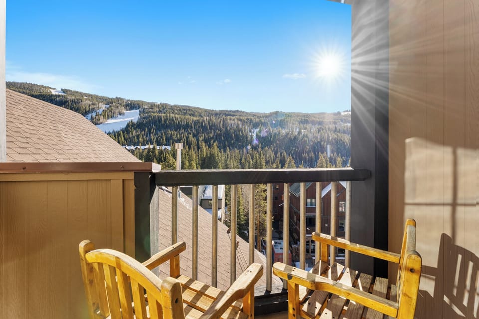 Breathe in crisp mountain air from your private balcony, where wooden chairs await your morning coffee moments against stunning alpine vistas.