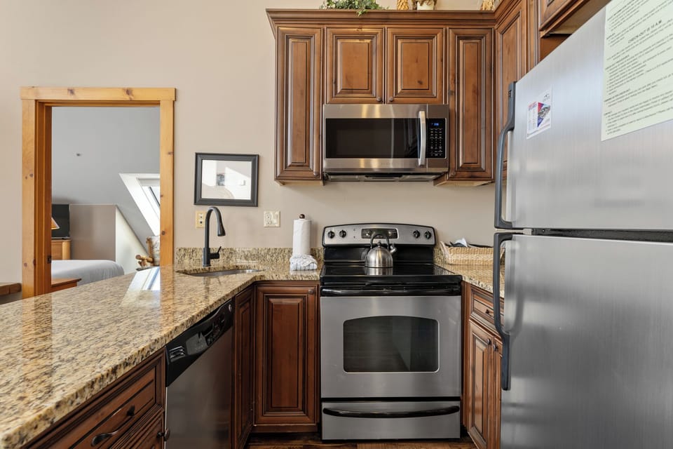 Your fully equipped kitchen features granite countertops, stainless steel appliances, and rich wood cabinetry for all your culinary adventures.