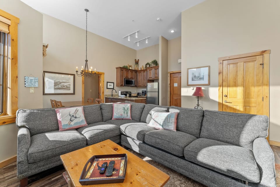 Sink into this cozy sectional sofa where you can unwind after mountain adventures, surrounded by warm wood accents and thoughtful décor.