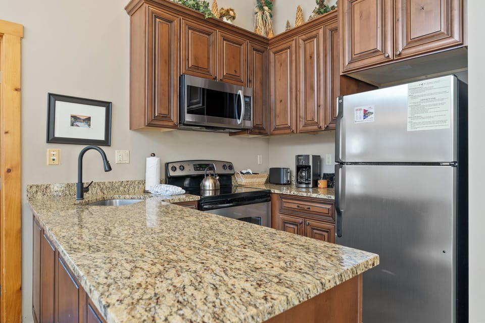 Your fully equipped kitchen features granite countertops, rich wood cabinets, and stainless steel appliances for preparing memorable meals together.
