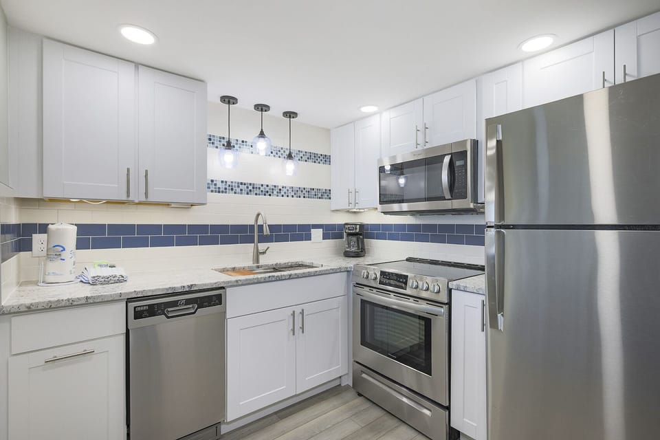 Stylish kitchen featuring stainless appliances, stylish lighting, and a sleek design, perfect for culinary adventures