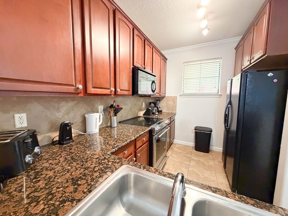 Fully equipped kitchen with granite countertops and stainless steel appliances in an Orlando vacation rental near Disney.