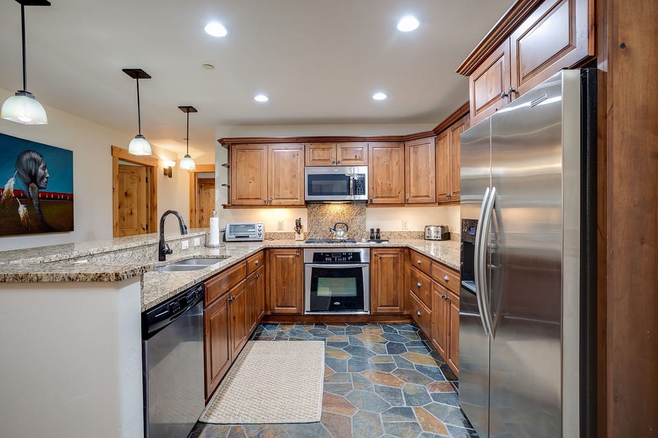 You'll love cooking in this spacious kitchen featuring warm wood cabinets, granite countertops, and stainless steel appliances.