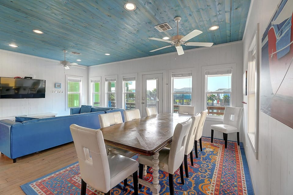 Gather around this spacious dining table beneath a stunning blue ceiling where memorable meals unfold with panoramic views.