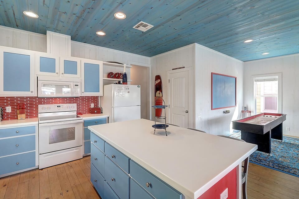 You'll love cooking in this vibrant blue kitchen with its spacious island and open flow to the game room for endless entertainment.