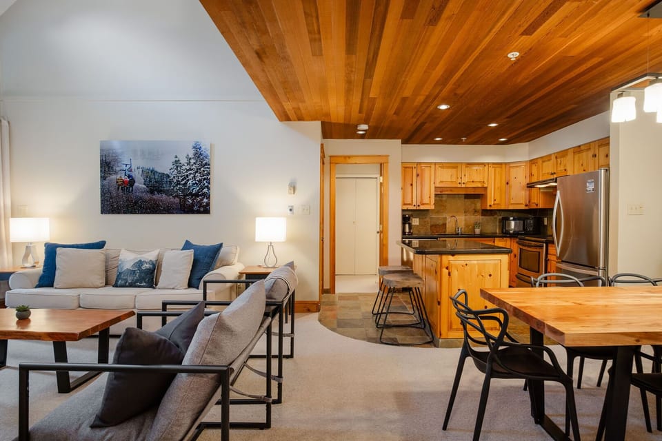 Open plan living/dining/kitchen with warm tones and vaulted ceilings, plus a wood-burning fireplace to complete the tranquil setting.