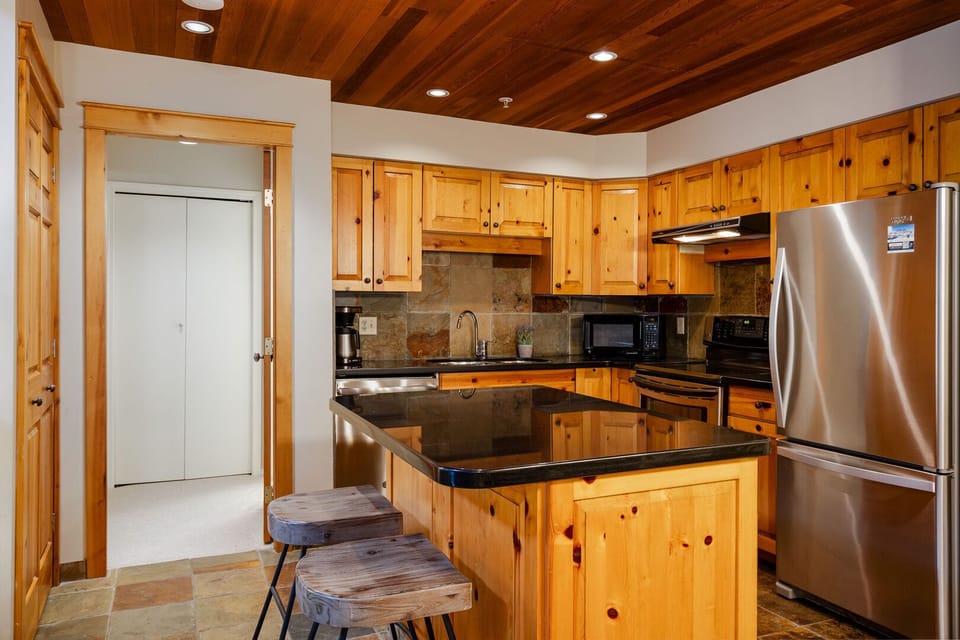 Modern kitchen with stainless steel appliances, and an island to connect in style.