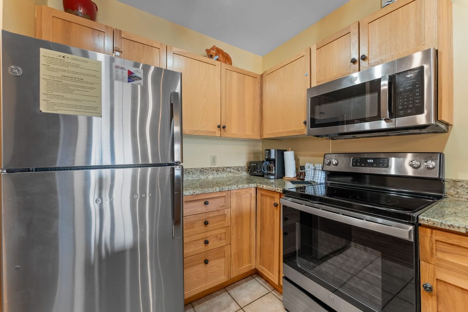 Your fully equipped kitchen features stainless steel appliances and warm wood cabinets, perfect for preparing memorable meals during your stay.