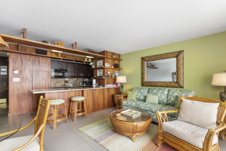 Unwind in your tropical-inspired living space, where warm wood tones and island-style furnishings create a relaxing retreat, complete with a full kitchen for all your vacation dining needs.