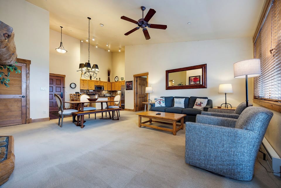 Unwind in your spacious open-concept living area, where soft lighting, comfortable seating, and a ceiling fan create a relaxing retreat after a day of mountain adventures.