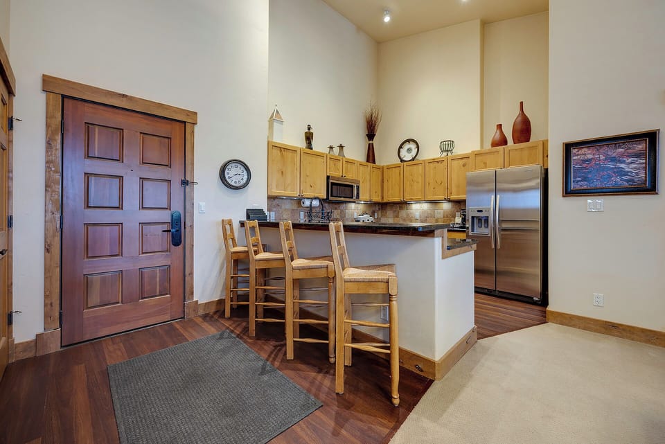 A welcoming open layout connects your entry to a fully equipped kitchen with breakfast bar, stainless appliances, and vaulted ceilings that create an airy mountain retreat.