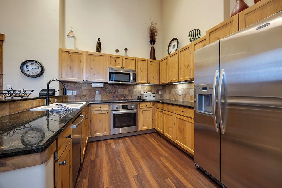 Your fully equipped kitchen features stainless steel appliances, granite countertops, and warm wood cabinetry—everything you need to whip up a home-cooked meal during your stay.
