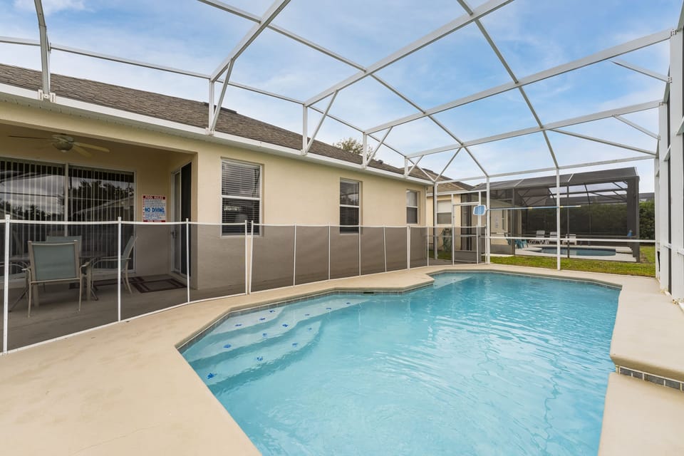 Screened in private pool with safety fence at a Central Florida vacation rental near Disney.